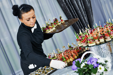 Waiter serving catering table