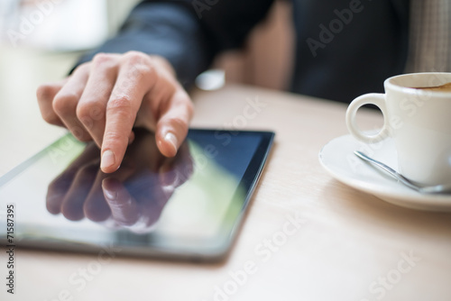 Fotografía Man with tablet computer reading news at motning in cafe