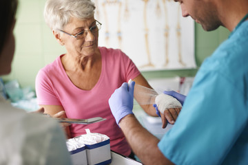 senior woman with bandage on the hand