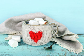 Fototapete - Cup of tasty hot cocoa, on wooden table, on color background