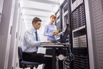 Poster - Team of technicians using digital cable analyser on servers