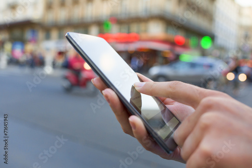Fotografie, Obraz Woman using her smart phone on the street in Paris