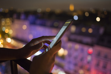 Woman using her mobile phone , city skyline night light