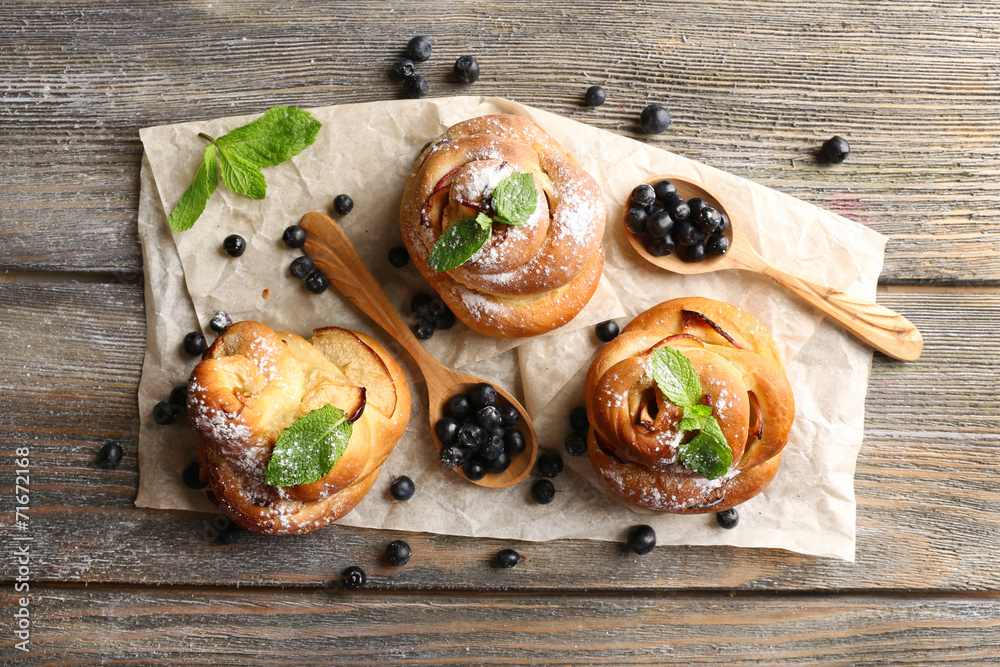 Tasty buns with berries on table close-up