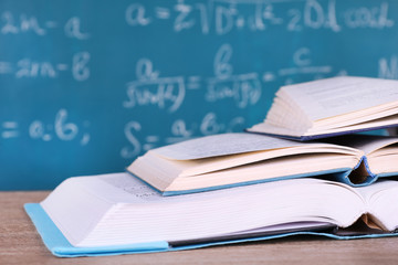 Sticker - Books on wooden table on blackboard background