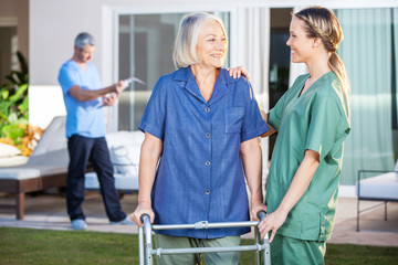 Wall Mural - Smiling Disabled Woman And Nurse Looking At Each Other