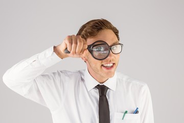 Poster - Geeky businessman looking through magnifying glass