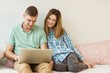 © WavebreakMediaMicro - Cute couple relaxing on couch with laptop