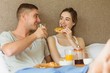 © WavebreakMediaMicro - Cute couple having breakfast in bed