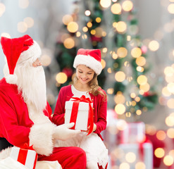 Wall Mural - smiling little girl with santa claus and gifts