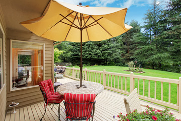 Patio table with yellow umbrella on walkout deck