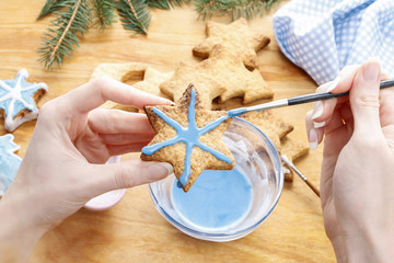 Wall Mural - Decorating gingerbread cookies with blue and white icing.