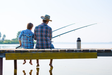 boy and his father fishing togethe