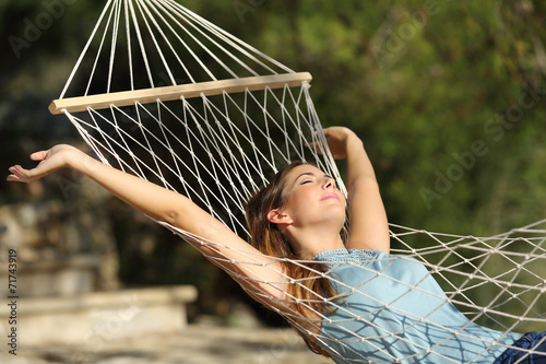 Fotografía Happy woman relaxing on a hammock on holidays and raising arms