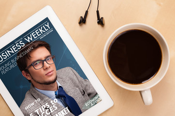 Wall Mural - tablet pc showing magazine on screen with a cup of coffee on a d