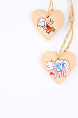 two wooden hearts on string forming Christmas pattern on white b