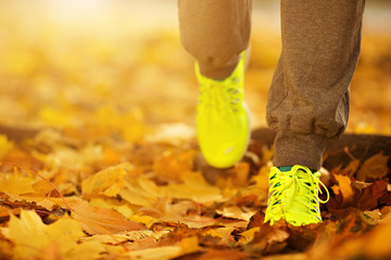 Wall Mural - Runner woman feet running on autumn road closeup on shoe. Female