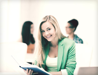 Canvas Print - smiling student girl reading book at school