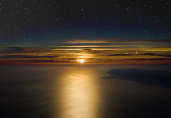 Wall Mural - high altitude sunset. stars above, cloudsand sea below.