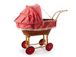 An old vintage childrens doll stroller over a white background