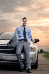 Handsome young man leaning on his car