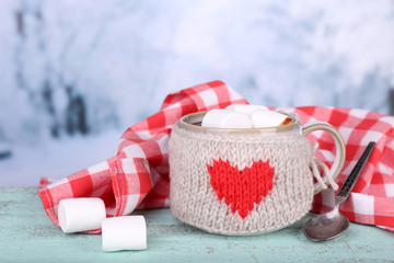 Fototapete - Cup of tasty hot cocoa, on wooden table, on light background