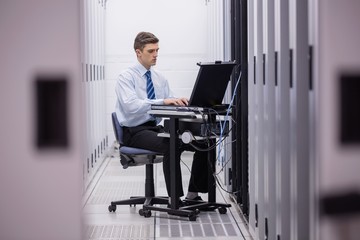 Poster - Technician sitting on swivel chair using laptop