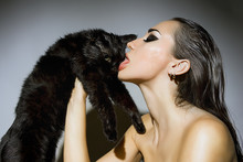Beautiful Sexy Woman With Glamour Make-up Licking A Cat. Fashion