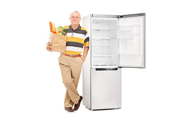 Poster - Senior holding a grocery bag by an empty fridge