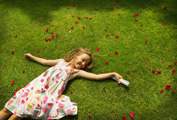 little girl resting on a green grass