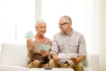 Poster - senior couple with money and calculator at home