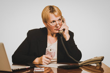Mature Businesswoman Waiting For Answer On The Phone With Money