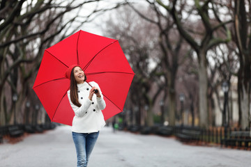 Wall Mural - Woman with red umbrella walking in park in fall