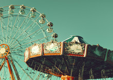 Vintage Chain Swing Ride And Ferris Wheel In An Amusement Park