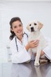 © WavebreakMediaMicro - Smiling veterinarian examining a cute dog