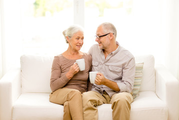 Canvas Print - happy senior couple with cups at home