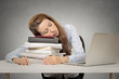© pathdoc - tired woman student sleeping on books at her desk