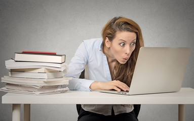 Shocked surprised woman using her laptop computer