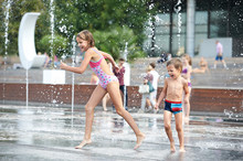 Happy Children Playing In A Fountain