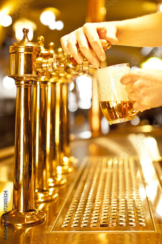 Foto Gold Bier in der Hand und Bierleitungen
