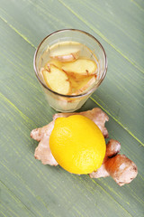 Wall Mural - Glasses of ginger drink and lemon on wooden background