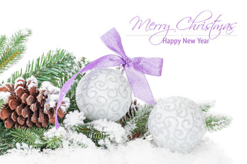 christmas baubles and purple ribbon with snow fir tree