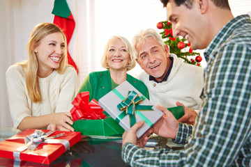 Paar mit Geschenken und Senioren an Weihnachten