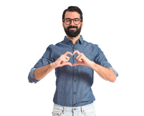 Wall Mural - Young hipster man making heart sign