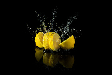 Sliced lemon splash on black background