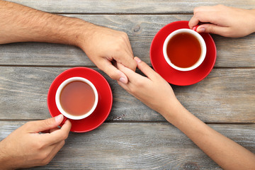 Poster - Loving couple with hot drinks on table