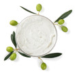 cosmetic cream in container and olives with leaves, top view