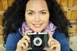 Brunette woman photographer holding an old camera