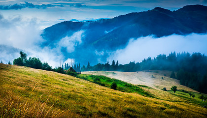 Wall Mural - amazing mountain landscape with fog and a haystack