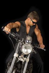 man on motorcycle black vest dark glasses look down